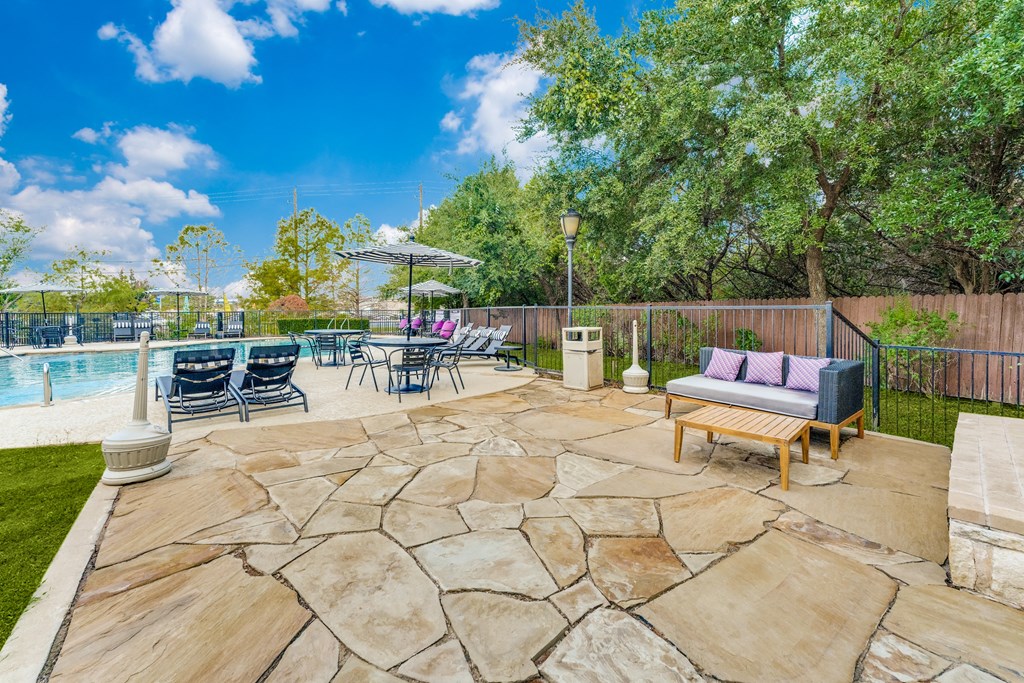the backyard has a pool and patio with furniture and chairs