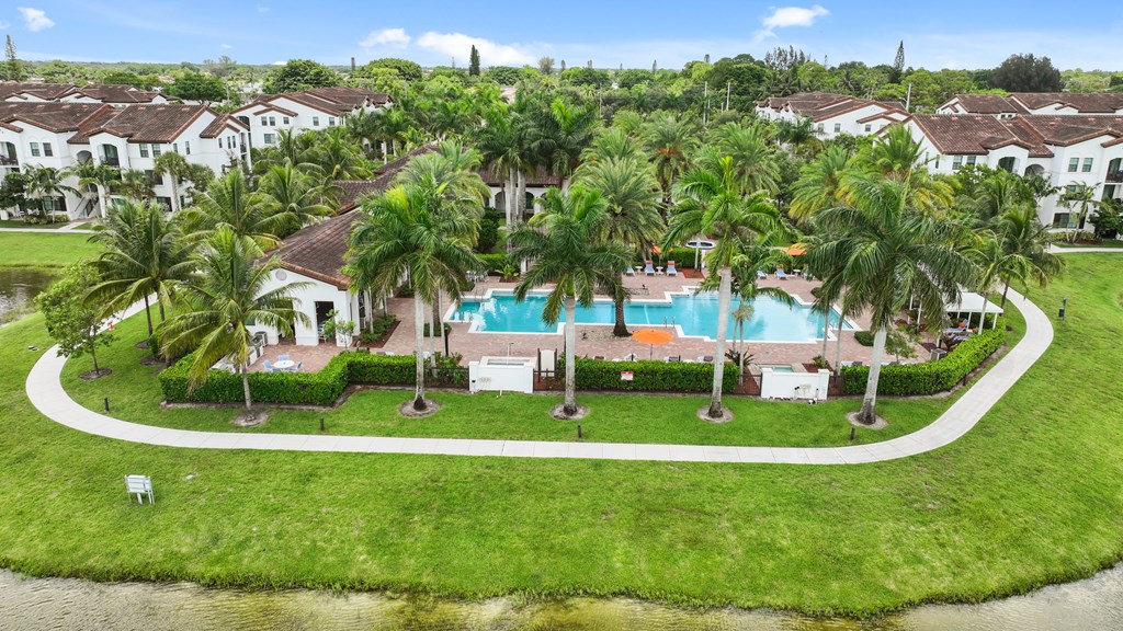 a mansion with a swimming pool surrounded by palm trees