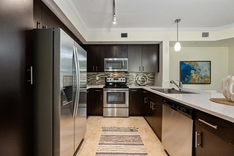 a modern kitchen with stainless steel appliances and black cabinets