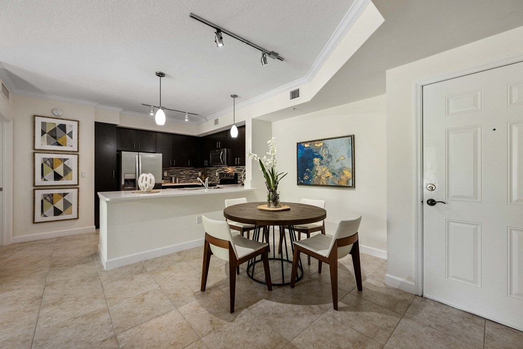 a dining room and kitchen with a table and chairs