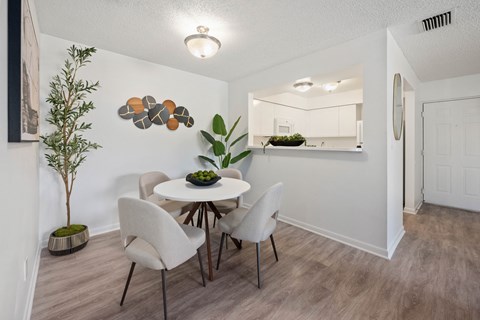 A dining room with a white table and chairs.
