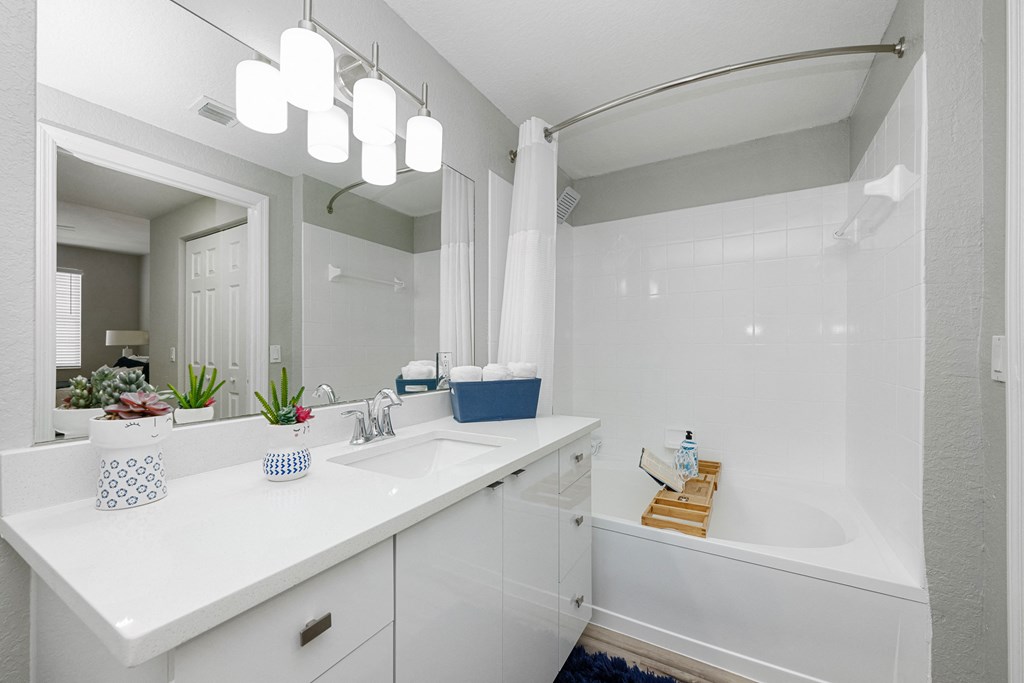 A white bathroom with a white tub and sink.