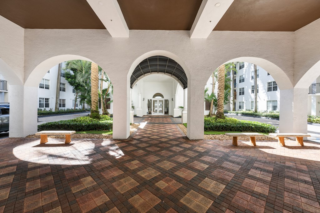 A courtyard with a tiled floor and arches.