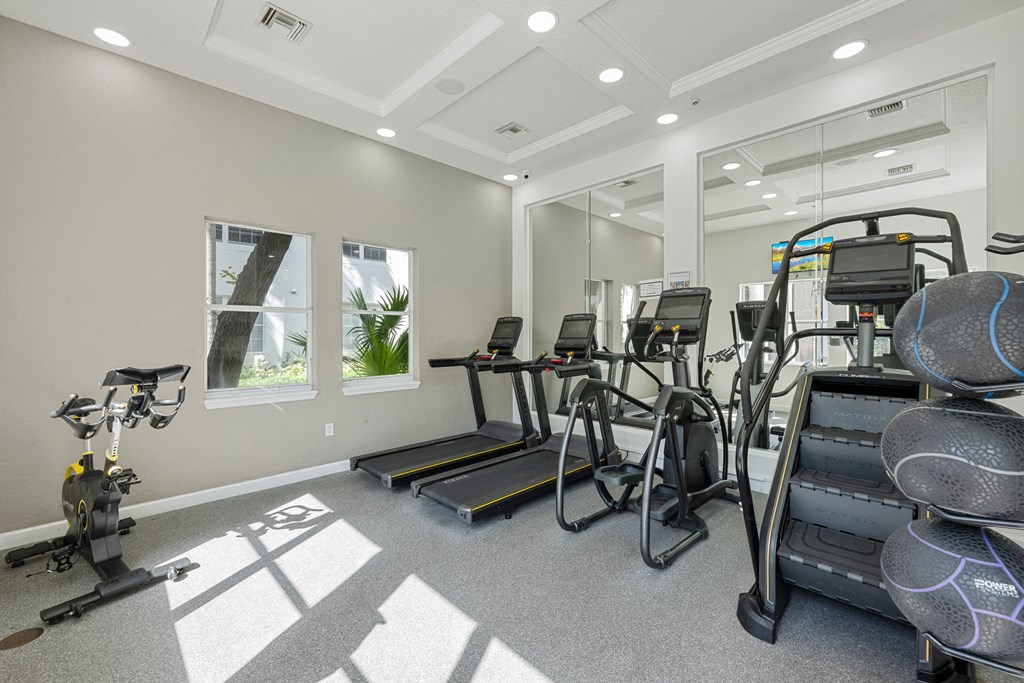 A spacious gym with treadmills, exercise bikes, and other equipment.