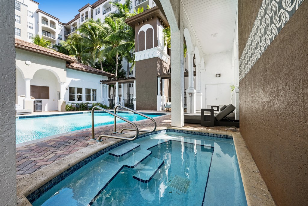 A swimming pool with a diving board and a building in the background.