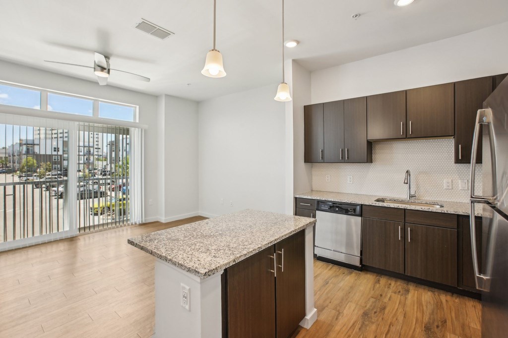 A kitchen with a granite countertop and stainless steel appliances.