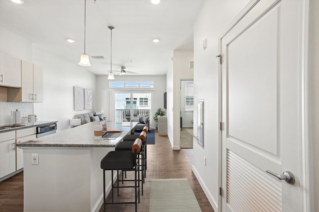 A modern kitchen with a bar area and a view of the outdoors.