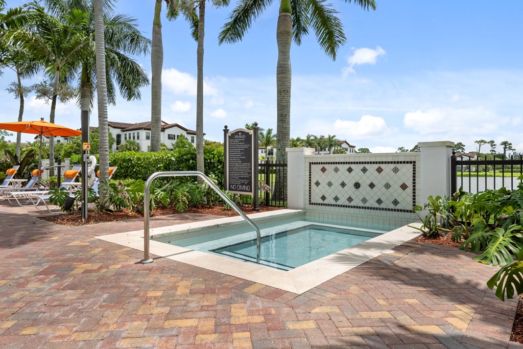 a small swimming pool in a backyard with palm trees