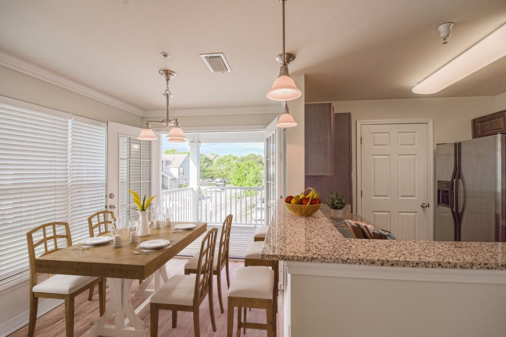 a kitchen and dining area with a wooden table and chairs