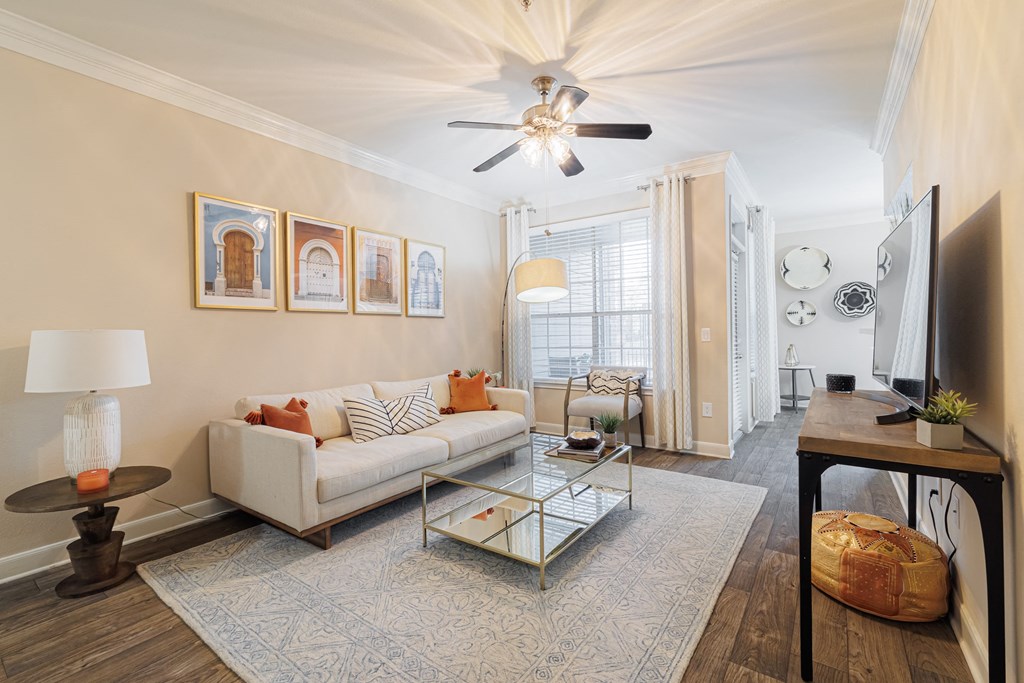 A living room with a white couch, a coffee table, and a ceiling fan.