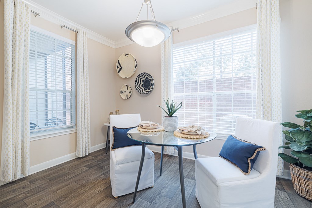 A dining area with a table, chairs, and a potted plant.
