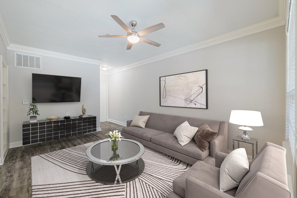 a living room with a couch and a table and a ceiling fan