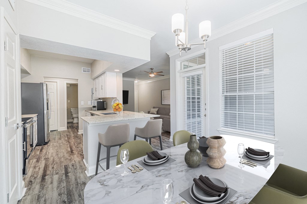 an open kitchen and dining room with a marble table and chairs