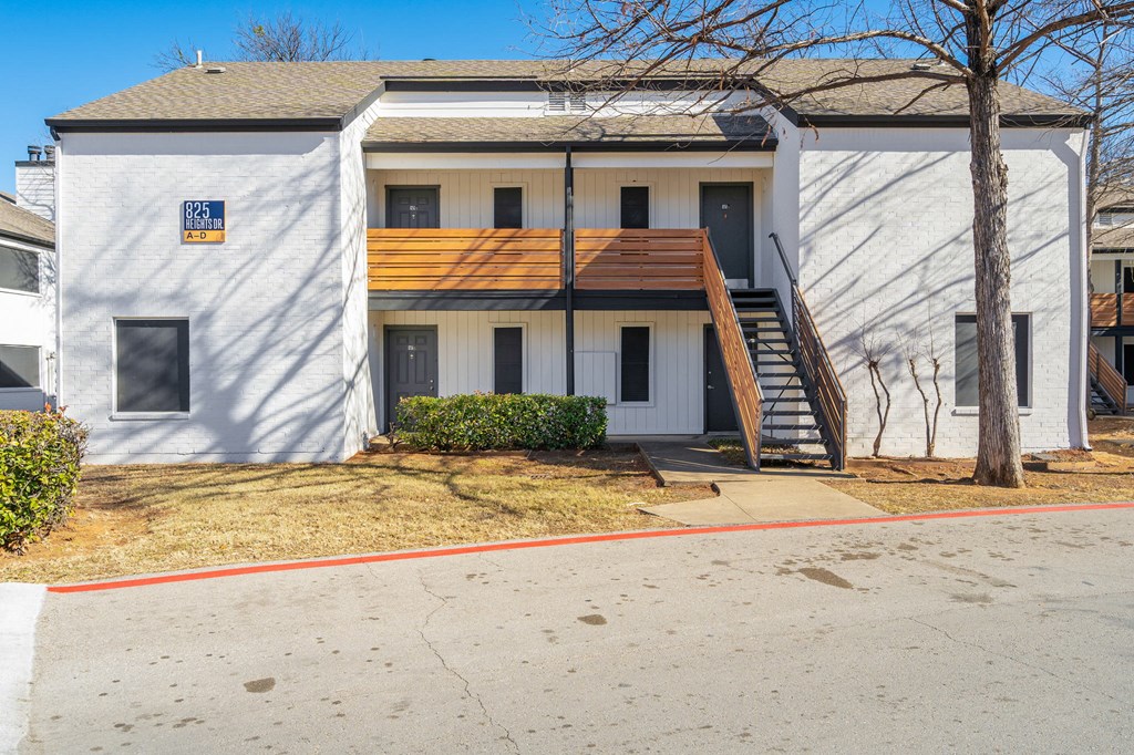 a white house with a porch and a tree in front of it