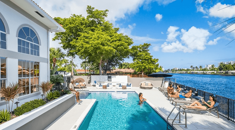 A group of people are enjoying the sun by a pool.