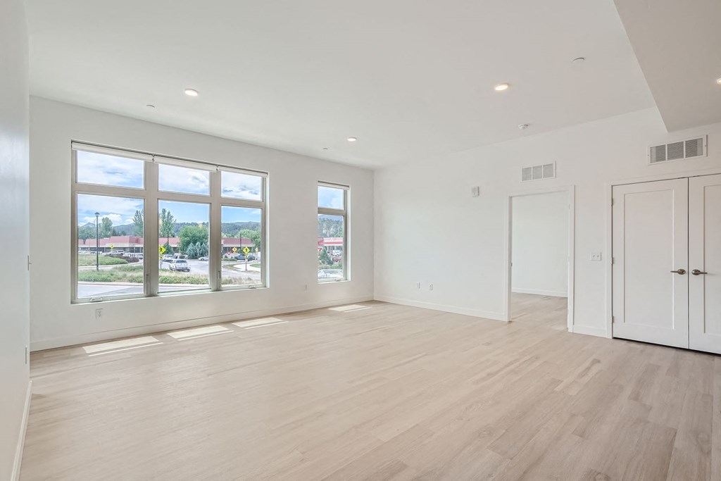 a bedroom with hardwood floors and white walls