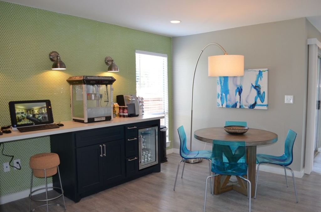 a dining area with a table and chairs and a coffee machine on a counter