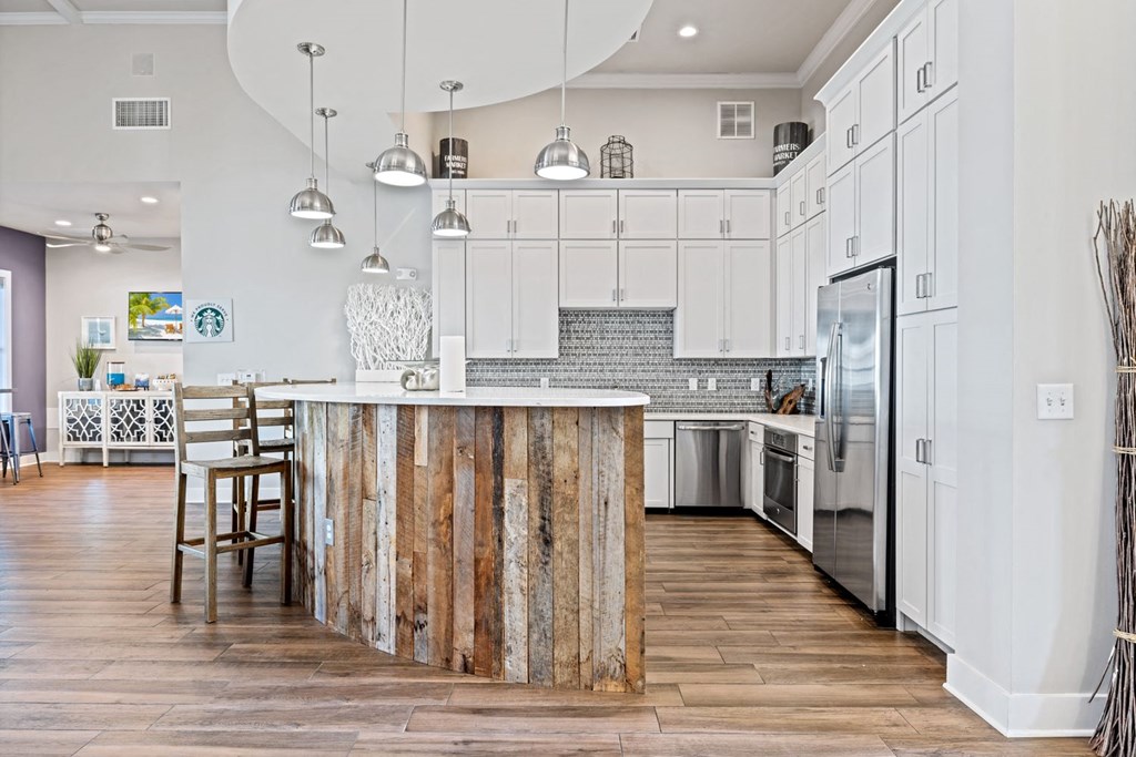 A kitchen with a wooden island and white cabinets.