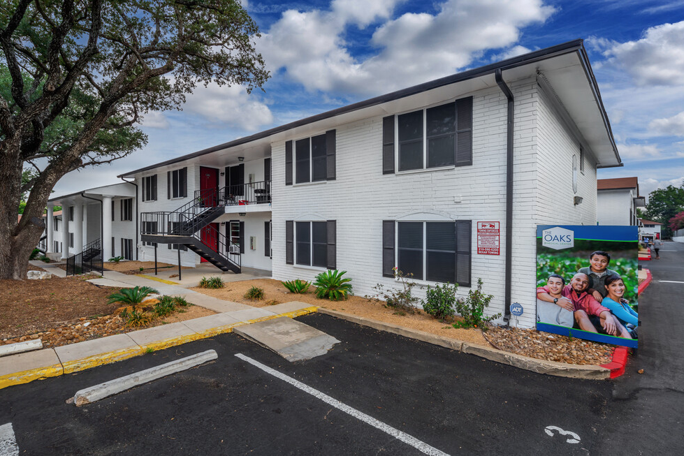 a white apartment building with a mural on the side of it