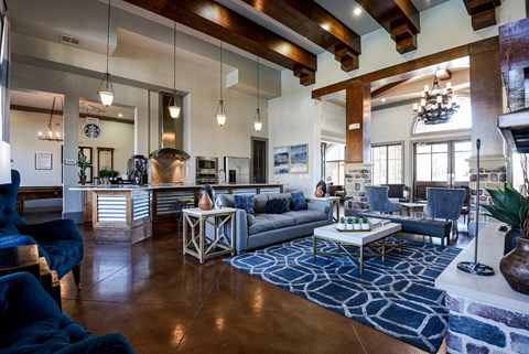 A living room with a blue rug and a grey couch.