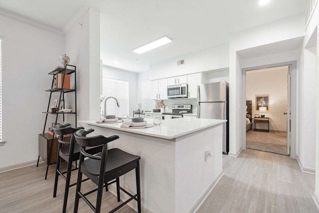 a kitchen with a large island with three stools