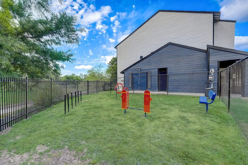 a large yard with two fire hydrants in the middle and a building in the background