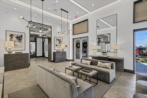 A modern living room with a grey sofa and a glass coffee table.