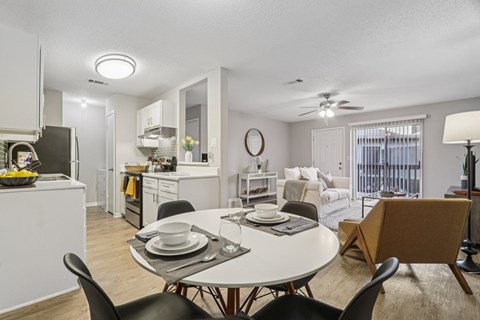 A modern dining room with a white table and chairs.