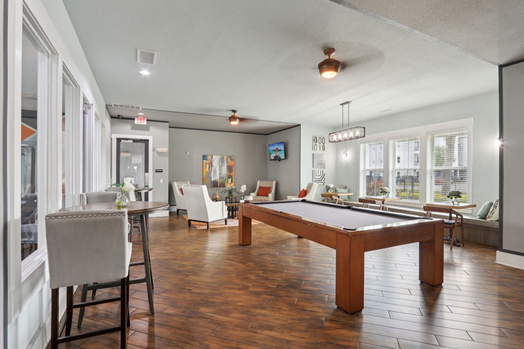 A room with a pool table and a television.