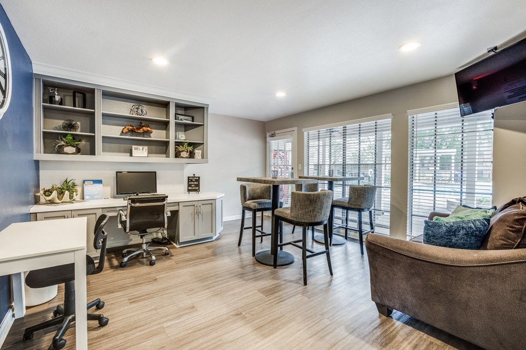 a home office with a desk and a chair and a table with chairs