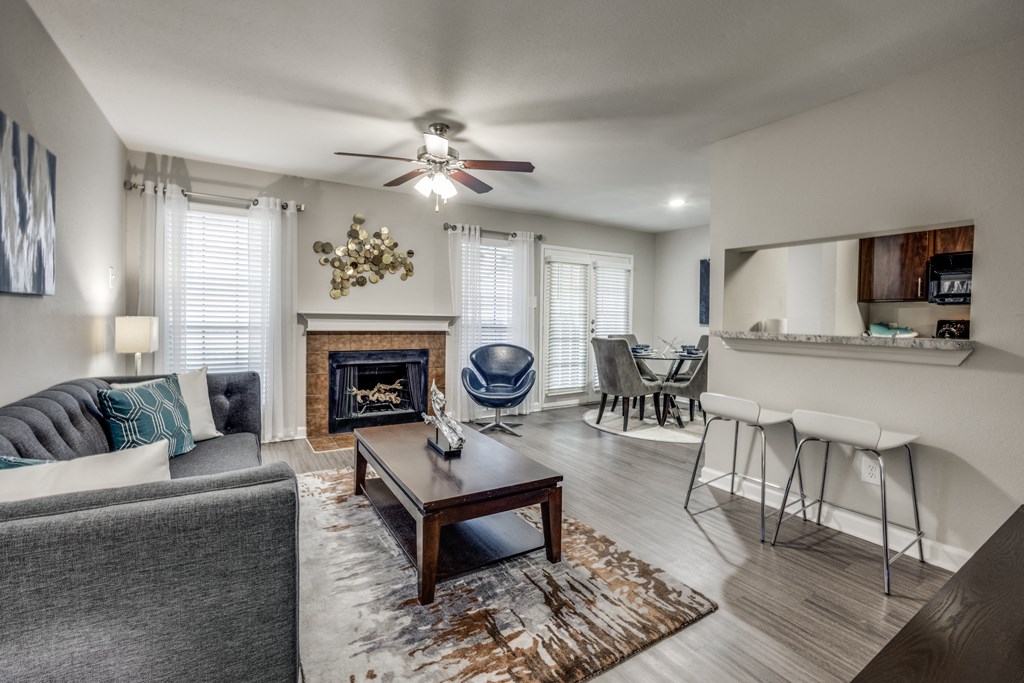 an open living room with a fireplace and a ceiling fan