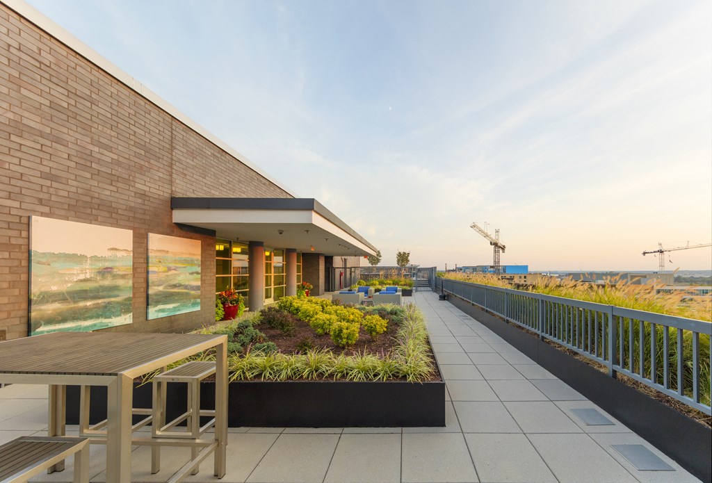 A modern building with a balcony and a table and chairs on it.
