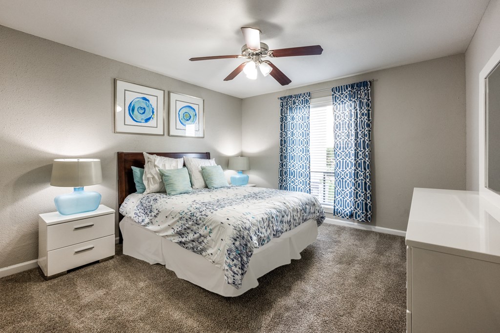 a bedroom with a bed and a ceiling fan