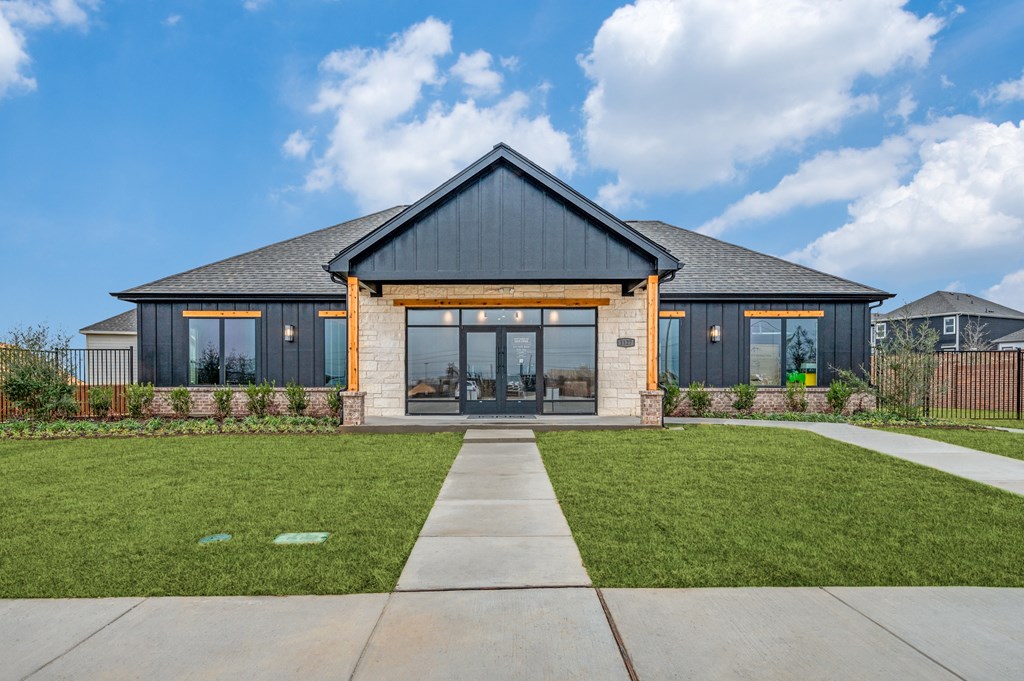 A modern house with a black roof and glass windows.