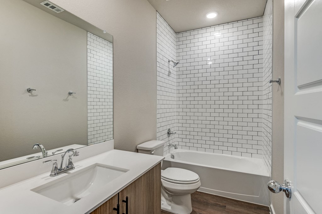 A white bathroom with a sink, toilet, and bathtub.