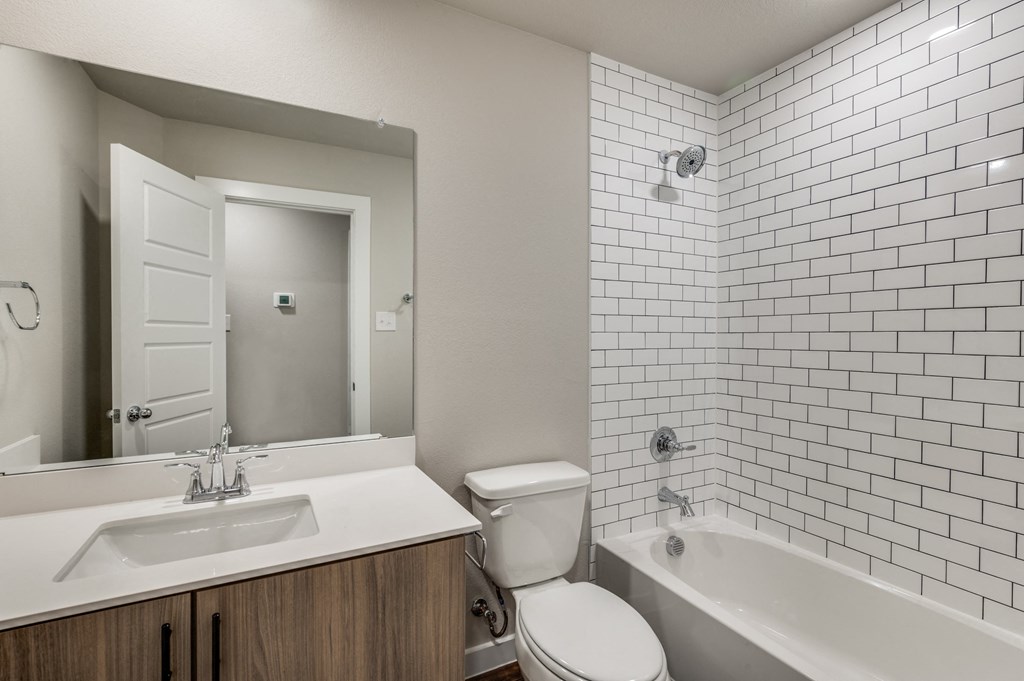 A white bathroom with a sink, toilet, and bathtub.