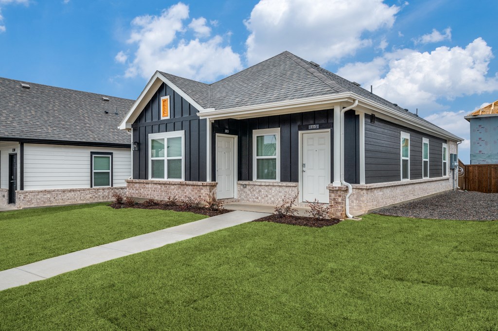 A house with a grey roof and white door.