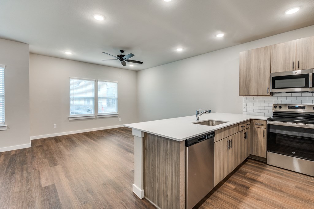 A kitchen with wooden floors and stainless steel appliances.