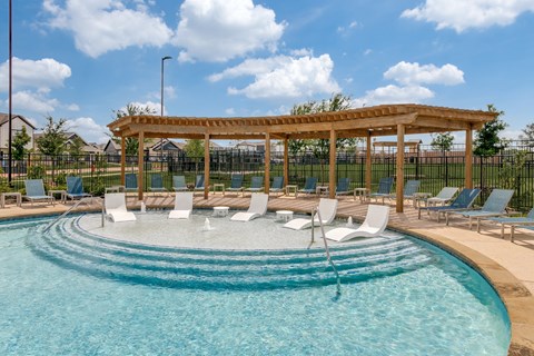 A pool with a wooden pergola and lounge chairs.