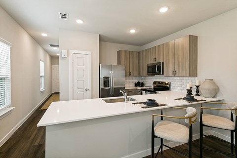 A kitchen with a white counter top and a white sink.