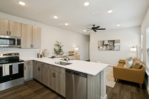 A modern kitchen with a stainless steel dishwasher and a white countertop.