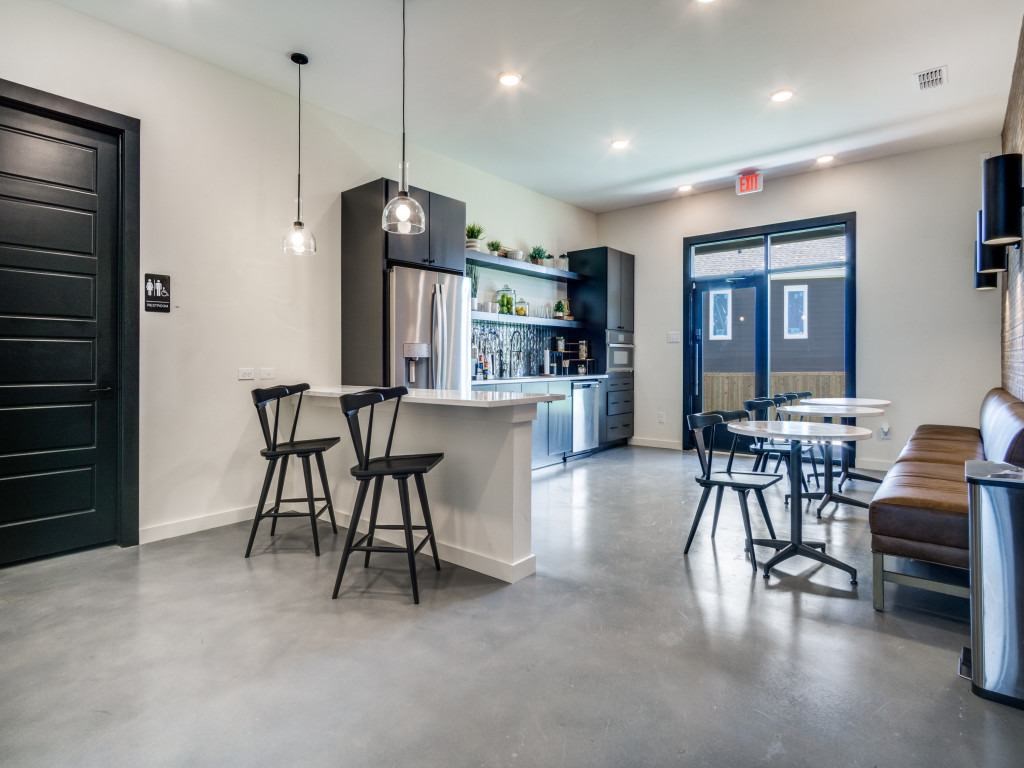 A modern kitchen with a bar area and a dining table.