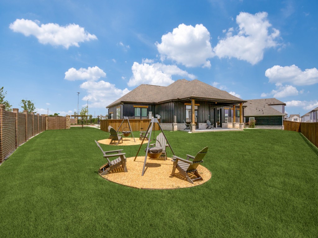 A house with a brown roof and a green lawn in front.