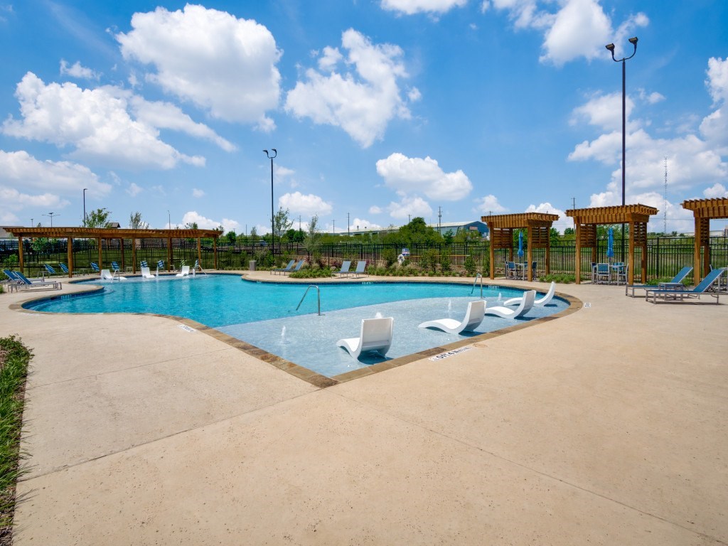 A large outdoor swimming pool with a sun lounger.