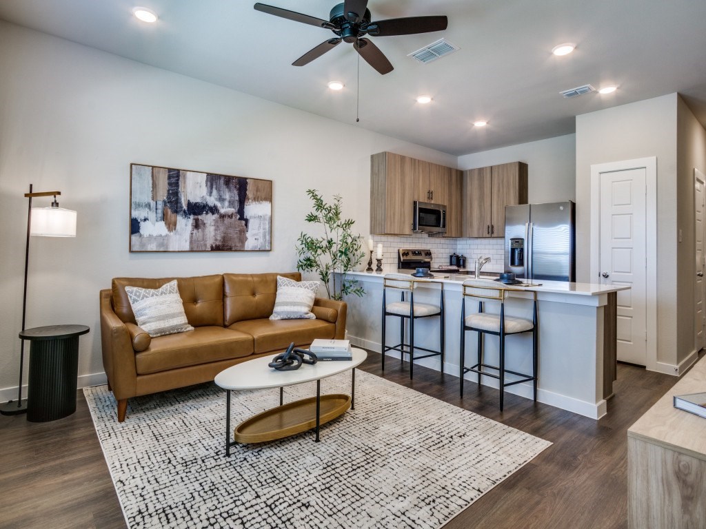 A modern living room with a brown sofa and a white coffee table.