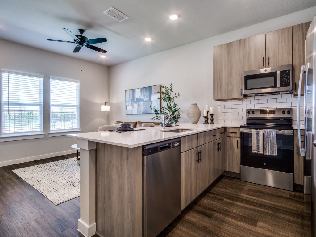 A modern kitchen with a large island and stainless steel appliances.
