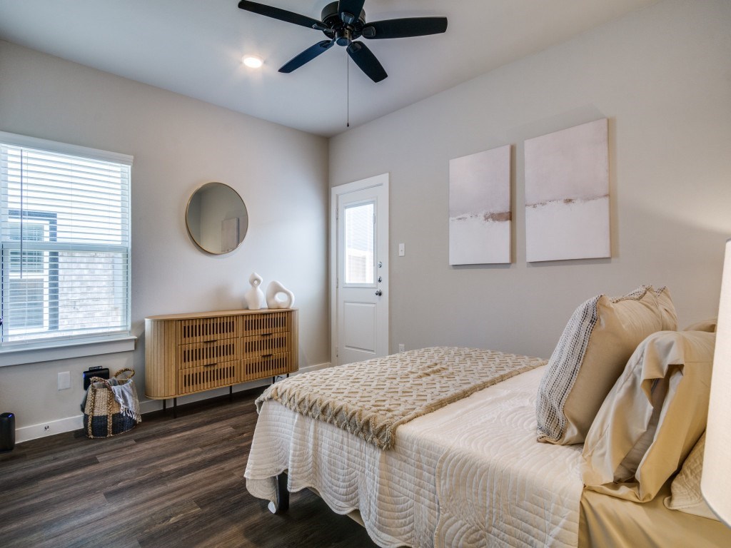 A bedroom with a bed, a ceiling fan, and a window with blinds.