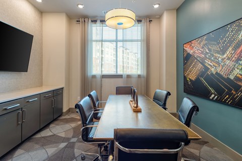 a conference room with a long table and chairs and a large painting on the wall