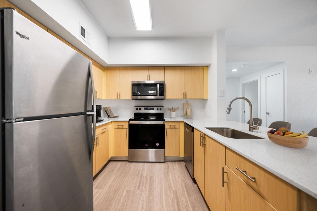 an empty kitchen with wooden cabinets and stainless steel appliances