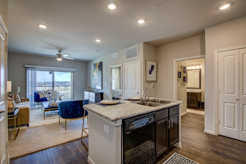 a kitchen with an island and a living room in the background